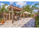 Charming backyard patio with pergola, dining set, and relaxing swing, surrounded by lush greenery at 477 44Th N Ave, St Petersburg, FL 33703