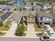 Aerial view of a neighborhood with well-maintained lawns, driveways, and neighboring houses, with a small pond in the distance at 5147 Brickwood Rise Dr, Wimauma, FL 33598