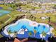 Aerial view of an outdoor community pool with a zero entry, lush landscaping, and a view of surrounding neighborhood at 5147 Brickwood Rise Dr, Wimauma, FL 33598