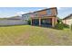 Large grass backyard with a screened in patio area and fenced perimeter at 5147 Brickwood Rise Dr, Wimauma, FL 33598