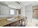 Bathroom with double sinks, granite countertop, and a shower tub combo at 5147 Brickwood Rise Dr, Wimauma, FL 33598