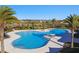 Beautiful community pool surrounded by tropical palm trees, lush greenery, and a spacious lounge area at 5147 Brickwood Rise Dr, Wimauma, FL 33598