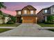 Two-story house with a driveway and attached two-car garage, surrounded by neatly manicured landscaping at 5147 Brickwood Rise Dr, Wimauma, FL 33598
