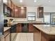 Well-equipped kitchen featuring granite countertops, dark cabinetry, and modern appliances, plus tile floor at 5147 Brickwood Rise Dr, Wimauma, FL 33598