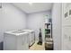 Laundry room featuring a washer, dryer, storage shelves, and a laundry basket at 5147 Brickwood Rise Dr, Wimauma, FL 33598