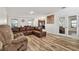 Spacious living room featuring hardwood floors, a large leather sofa, and plenty of natural light at 5147 Brickwood Rise Dr, Wimauma, FL 33598