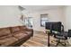 Cozy living area featuring hardwood floors, a comfortable sofa, and ample natural light from the window at 5147 Brickwood Rise Dr, Wimauma, FL 33598