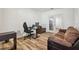 Home office featuring a desk, rolling chair, hardwood floors, and a comfortable brown sofa at 5147 Brickwood Rise Dr, Wimauma, FL 33598