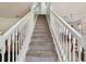 Carpeted staircase with white banister and railing leads to the upper level at 5147 Brickwood Rise Dr, Wimauma, FL 33598