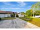 Charming home exterior featuring a well-manicured lawn, mature trees, and a private driveway at 5310 Bellefield Dr, Tampa, FL 33624