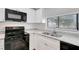 Modern kitchen featuring granite countertops, stainless steel sink, and black appliances at 5310 Bellefield Dr, Tampa, FL 33624