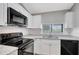 Modern kitchen featuring granite countertops, stainless steel sink, and black appliances at 5310 Bellefield Dr, Tampa, FL 33624