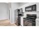 Well-lit kitchen featuring granite countertops, white cabinets, and black appliances at 5310 Bellefield Dr, Tampa, FL 33624