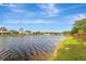 Calm waterfront scene showing grassy edges, still water, and residential homes under a partly cloudy sky at 5310 Bellefield Dr, Tampa, FL 33624