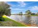 Beautiful waterfront view featuring calm water, verdant shoreline, and mature trees under a bright sky at 5310 Bellefield Dr, Tampa, FL 33624