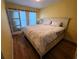 Cozy bedroom featuring hardwood floors and a queen-size bed with sliding door closet at 5712 Biscayne Ct # 203, New Port Richey, FL 34652