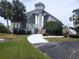 Attractive coastal building with gray siding, tower feature, manicured landscaping and accessible entry ramp at 5712 Biscayne Ct # 203, New Port Richey, FL 34652