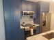 Modern kitchen with stainless steel appliances and stylish blue cabinetry at 5712 Biscayne Ct # 203, New Port Richey, FL 34652