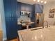 Stylish kitchen featuring blue cabinets, granite countertops, and stainless steel appliances at 5712 Biscayne Ct # 203, New Port Richey, FL 34652