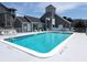 Refreshing community pool with surrounding patio, lounge chairs, and easy access to nearby buildings at 5712 Biscayne Ct # 203, New Port Richey, FL 34652