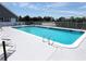 Well-maintained community pool surrounded by fencing, with lounge chairs for relaxing in the sun at 5712 Biscayne Ct # 203, New Port Richey, FL 34652