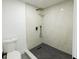 Modern bathroom features tiled walk-in shower with rainfall shower head, toilet, and herringbone-patterned shower floor at 5806 12Th S Ave, Tampa, FL 33619