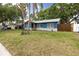 Landscaped single-story home with blue paint, white trim, and a well-manicured front lawn at 5806 12Th S Ave, Tampa, FL 33619