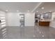 Open-concept living space with gray tile floors, leading to kitchen with modern gray cabinets at 5806 12Th S Ave, Tampa, FL 33619