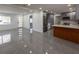 Open-concept living space with gray tile floors and a modern kitchen with stainless steel appliances at 5806 12Th S Ave, Tampa, FL 33619