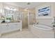 Bathroom featuring a soaking tub, separate glass enclosed shower, double vanity and tile flooring at 600 Bayway Blvd # 504, Clearwater Beach, FL 33767