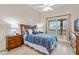 Light-filled bedroom with wood floors, ceiling fan, wood furniture and bright window at 600 Bayway Blvd # 504, Clearwater Beach, FL 33767