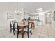 Spacious dining area with an elegant chandelier, wood table, and comfortable chairs, open to the bright kitchen at 600 Bayway Blvd # 504, Clearwater Beach, FL 33767