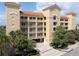 Stunning condo building featuring multiple stories, balconies, and a red tile roof complemented by lush landscaping at 600 Bayway Blvd # 504, Clearwater Beach, FL 33767
