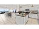 Open-concept kitchen featuring white cabinets, granite countertops, an island, and a breakfast bar overlooking the living area at 600 Bayway Blvd # 504, Clearwater Beach, FL 33767
