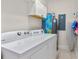 Bright laundry area with washer, dryer, overhead cabinets, water heater, and tiled flooring at 600 Bayway Blvd # 504, Clearwater Beach, FL 33767