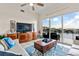 Bright living room featuring tile floors, comfortable seating, and a large window showcasing beautiful water views at 600 Bayway Blvd # 504, Clearwater Beach, FL 33767