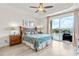 Bright bedroom featuring tray ceilings, a floral comforter, and sliding glass doors opening to a balcony at 600 Bayway Blvd # 504, Clearwater Beach, FL 33767