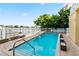 Sparkling community swimming pool surrounded by brick pavers, lush greenery, and comfortable seating at 600 Bayway Blvd # 504, Clearwater Beach, FL 33767