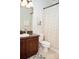 Cozy bathroom featuring a vanity with dark wood cabinets, toilet, and patterned shower curtain at 6931 Surrey Hill Pl, Apollo Beach, FL 33572