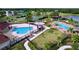 Aerial shot of the community pool area with splash pad, pools, palm trees and shaded seating at 6931 Surrey Hill Pl, Apollo Beach, FL 33572