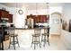 Open-concept kitchen with stainless steel appliances, dark wood cabinetry, bar seating, and elegant pendant lighting at 6931 Surrey Hill Pl, Apollo Beach, FL 33572
