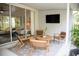 Inviting covered patio includes a modern seating arrangement and a mounted TV for relaxation at 6931 Surrey Hill Pl, Apollo Beach, FL 33572
