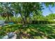 Green backyard featuring well maintained lawn, a fire pit and lush green landscaping at 8421 Millwood Dr, Tampa, FL 33615