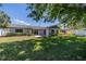 Expansive backyard with lush green lawn, mature trees, a fire pit, and a patio for outdoor enjoyment at 8421 Millwood Dr, Tampa, FL 33615