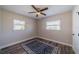 Bright bedroom with hardwood floors, two windows, and a simple blue patterned rug at 8421 Millwood Dr, Tampa, FL 33615