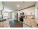 Bright kitchen featuring stainless steel appliances, granite countertops, and white cabinetry at 8421 Millwood Dr, Tampa, FL 33615