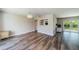 Bright, open-concept living area featuring laminate flooring, access to the kitchen, and a sliding glass door to the backyard at 8421 Millwood Dr, Tampa, FL 33615