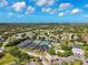 Scenic aerial view of tennis courts and clubhouse with plenty of parking surrounded by lush landscapes at 8703 Bardmoor Blvd # 304, Seminole, FL 33777