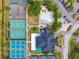 Overhead shot of tennis courts, a pool, and clubhouse surrounded by parking and landscaping at 8703 Bardmoor Blvd # 304, Seminole, FL 33777