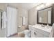 Cozy bathroom featuring a vanity with framed mirror, toilet, and shower with decorative tiles and a white shower curtain at 8703 Bardmoor Blvd # 304, Seminole, FL 33777